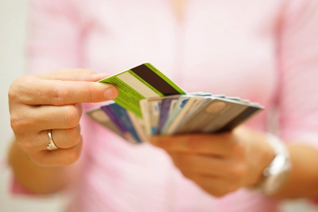 A person holding up several credit cards in their hands.