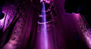 A purple light is shining in the middle of a cave.