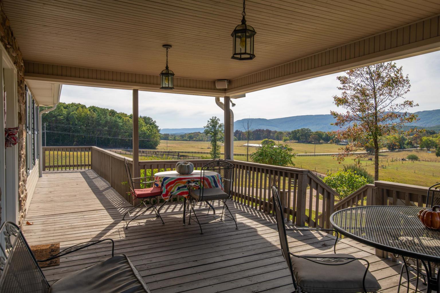 A porch with chairs and tables on it