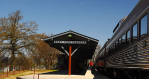 A train station with people walking on the platform.