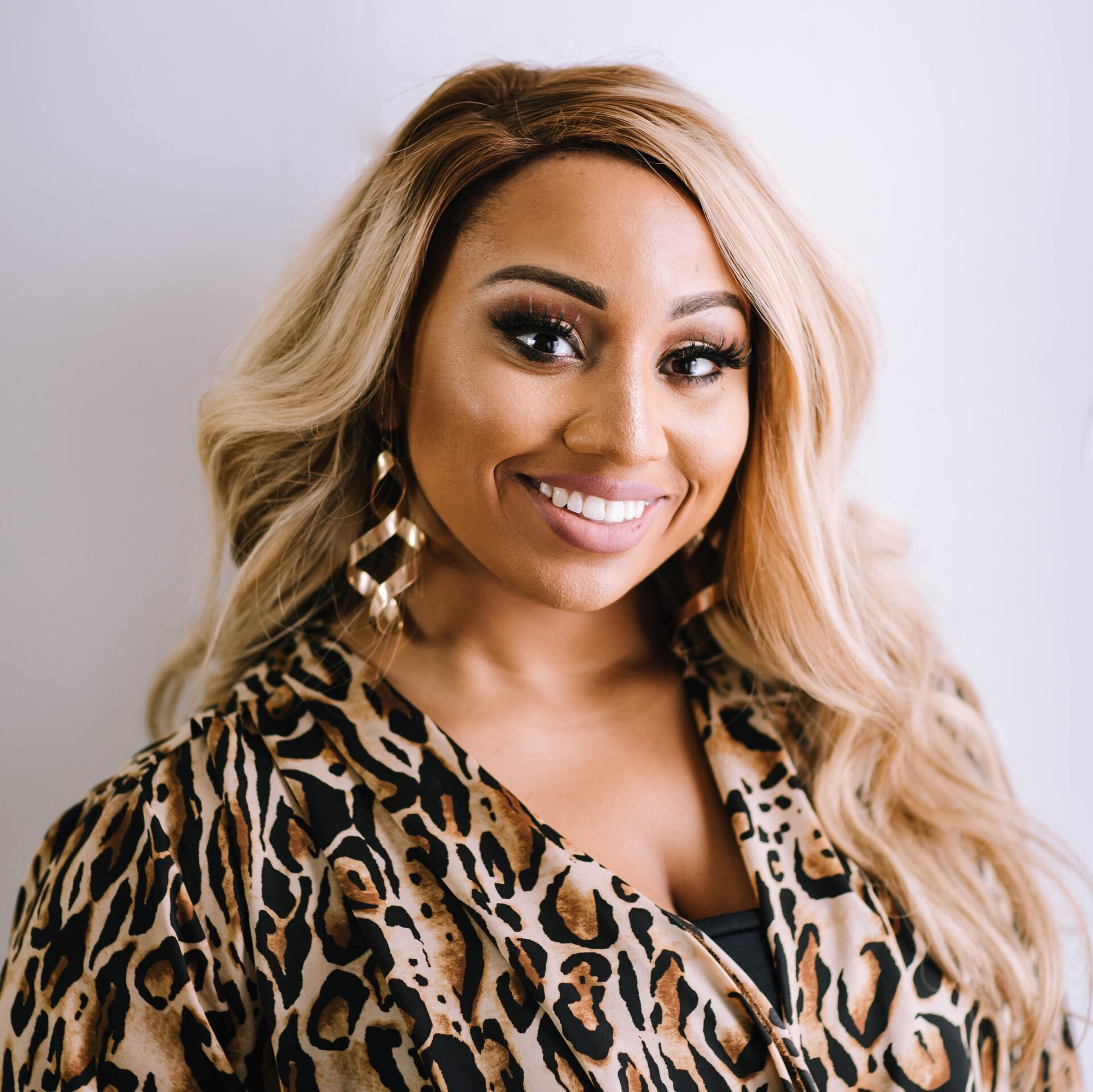 A woman with long blonde hair wearing leopard print.