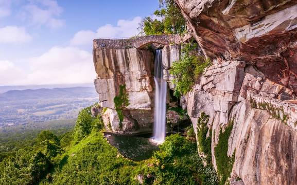 A waterfall is shown on the side of a cliff.