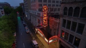 A large neon sign is lit up on the side of a building.