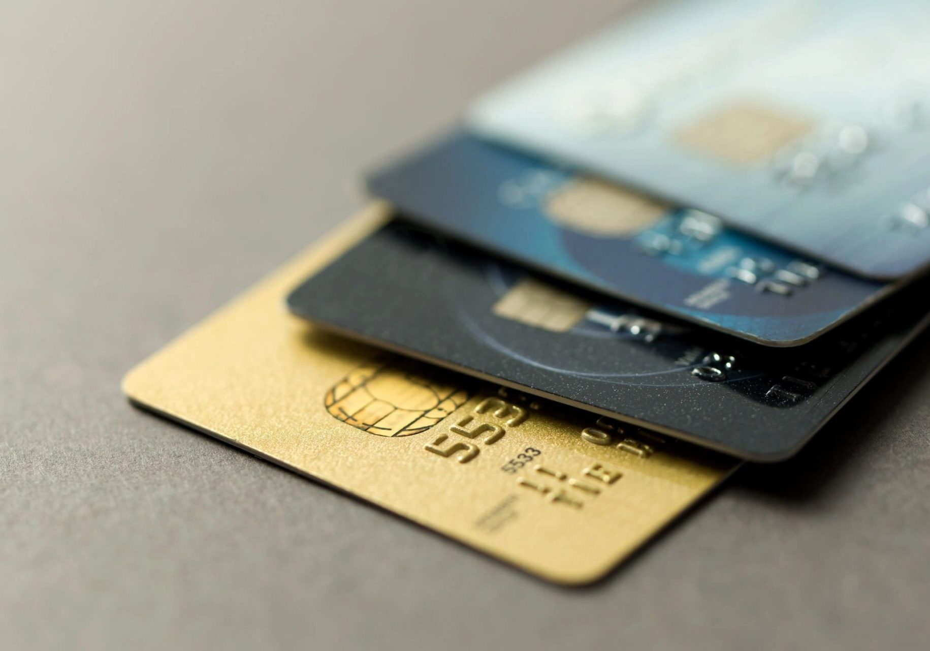 fm=f_6075 A close up of three credit cards on top of each other.