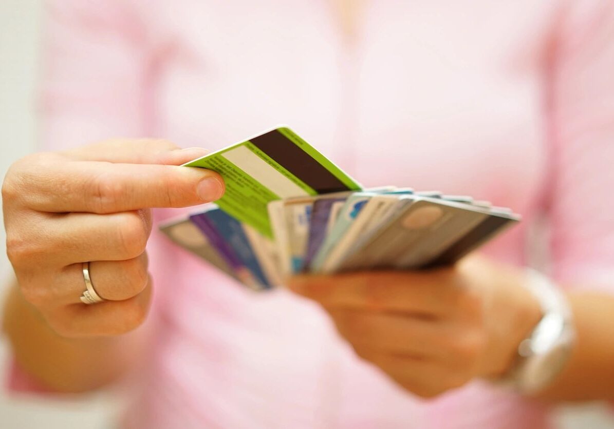 fm=f_V5lGYW7 A person holding up several credit cards in their hands.