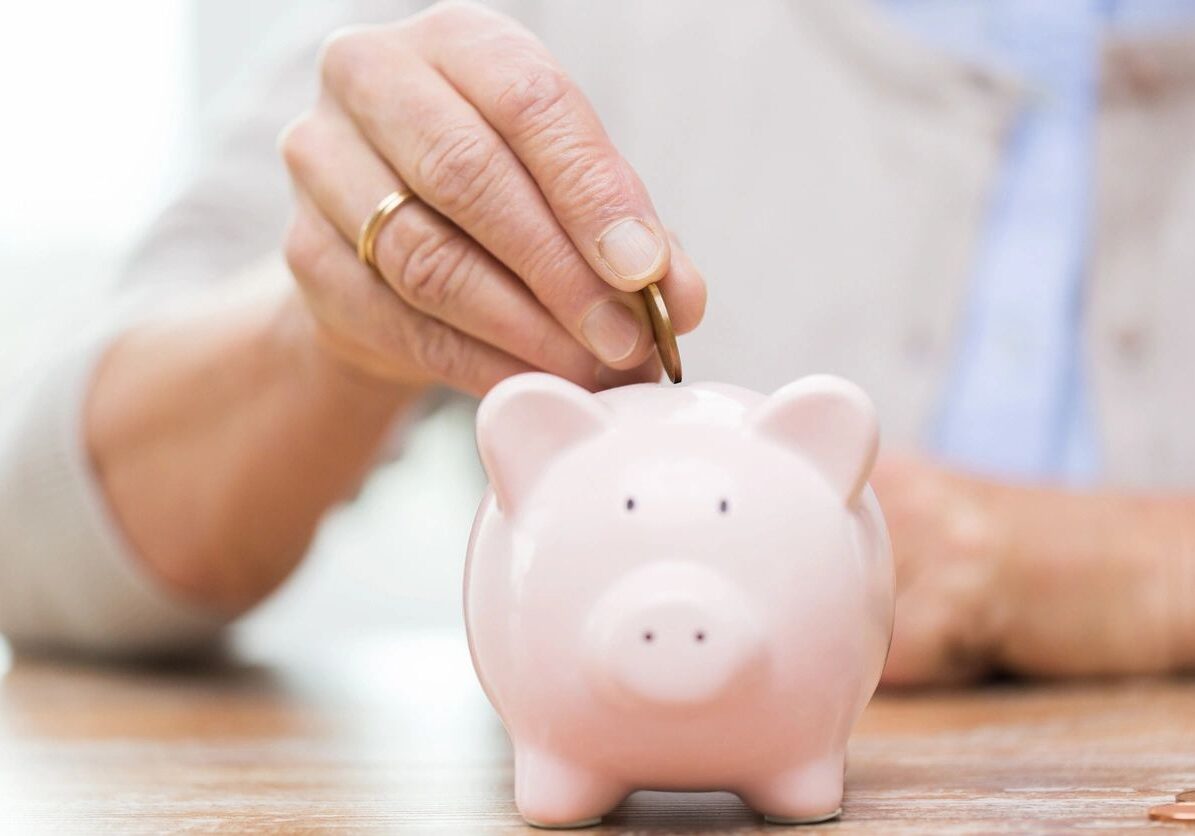 A person putting money into a piggy bank